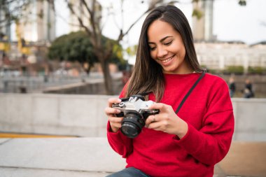 Açık havada profesyonel dijital kamera kullanan genç fotoğrafçı kadının portresi. Fotoğraf konsepti