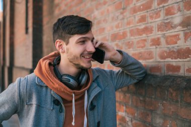 Sokakta telefonda konuşan genç Latin bir adamın portresi. Kentsel ve iletişim konsepti.