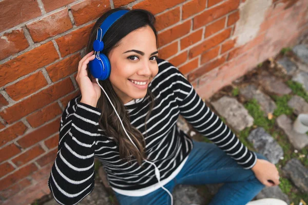 Portrét Mladé Krásné Ženy Poslouchající Hudbu Modrými Sluchátky Ulici Venku — Stock fotografie