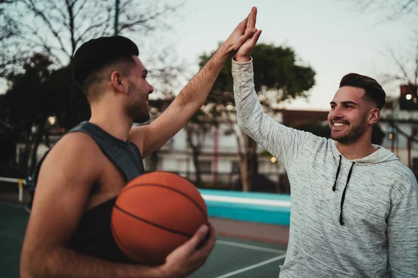 バスケットボールをしている2人の若い友人の肖像画と屋外で裁判所で楽しんでいます スポーツコンセプト — ストック写真