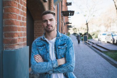 Sokaklarda günlük giysiler giyen yakışıklı bir gencin portresi. Şehir konsepti.