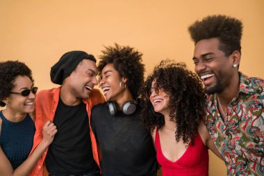 Afro arkadaşların portresi birlikte eğleniyor ve sarı arka planda iyi vakit geçiriyor. Arkadaşlık ve yaşam tarzı kavramı.