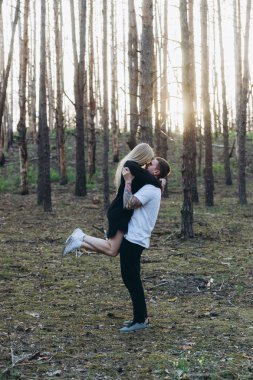 Dövmeli adam holding kız woods, havada yan görünüm