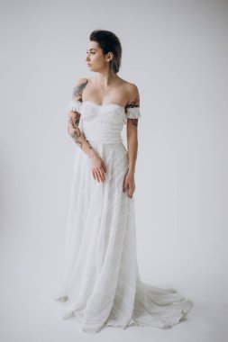 boho tarzında elbise giyen açık arka planda poz kadın yan görünümü  