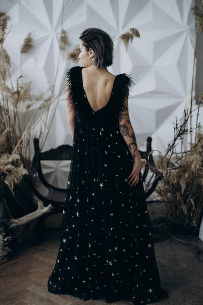 Vista Posterior Mujer Tatuada Con Vestido Negro Largo Pie Estudio — Foto de Stock