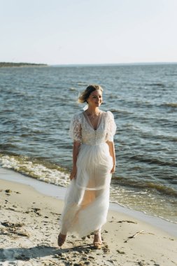neşeli genç kadın gündüz plajda yürüyüş 