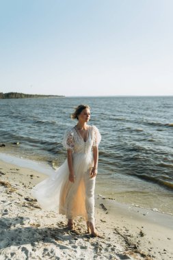 neşeli genç kadın gündüz plajda yürüyüş 