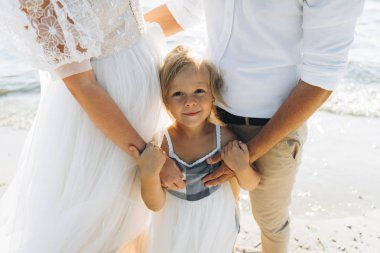 sahilde küçük kızı sarılma ebeveynlerin kırpılmış çekim 