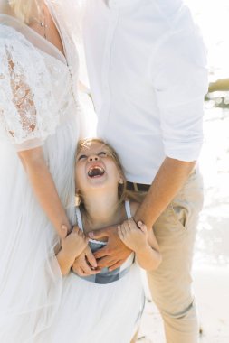 sahilde küçük kızı sarılma ebeveynlerin kırpılmış çekim 