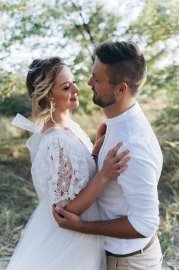 gelin ve damat portresi birbirlerine açık havada bakıyor  