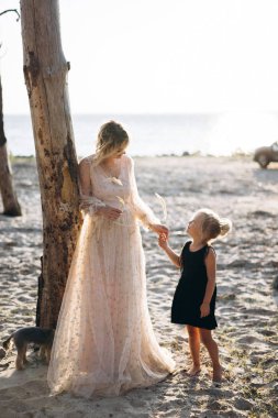 plajda uzun elbiseli anne sarılma neşeli kız, Tam Uzunlukta atış