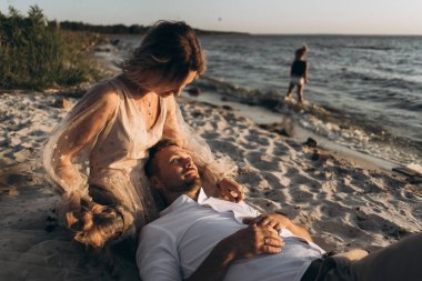 plajda köpek ile kadın tur yatan adam 