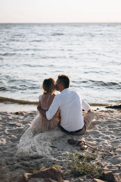 男人和女人在日落时在海滩上接吻 — 图库照片