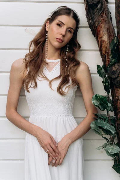 açık havada beyaz ahşap arka plan karşı duran kameraya bakan gelin portresi 