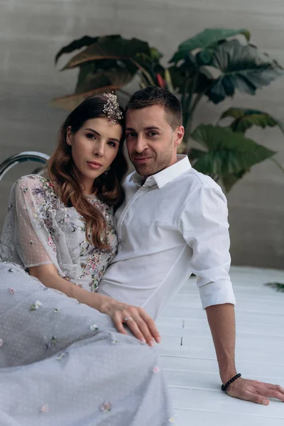 yakışıklı adam ve genç kadın yüzme havuzunda oturan ve kameraya bakarak 