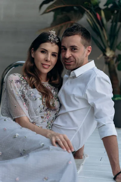 yakışıklı adam ve genç kadın yüzme havuzunda oturan ve kameraya bakarak 