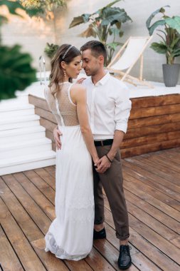 Arka planda yüzme havuzu ile bahçesinde kucaklayan gelin ve damadın Tam Uzunlukta çekim