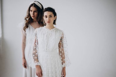 iki şık genç kadın kameraya bakarak ve ışık arka planda poz, kopya alanı 