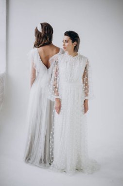 Iki genç kadın ışık arka planda arka arkaya ayakta