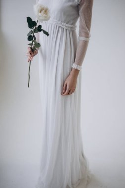 beyaz elbise giyen ve çiçek kokulu Açık arka plan üzerinde duran kadın kırpılmış çekim 