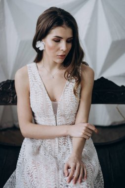 ahşap bankta oturan boho tarzıbeyaz elbise giyen çekici model 