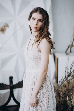 stüdyoda boho tarzında elbise giyen ve kameraya bakan genç bayan 