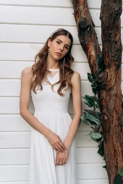 açık havada beyaz ahşap arka plan karşı duran kameraya bakan gelin portresi 