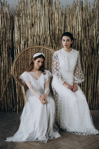 Dos Señoras Vestidos Blancos Sentadas Una Silla Grande Estudio Posando —  Fotos de Stock