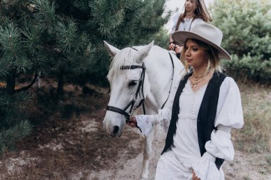 kızı binicilik atı ile dizgin tutan şık kadın