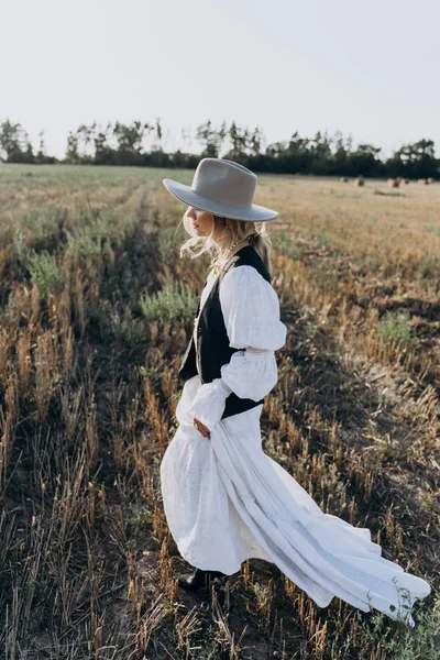 Uzun Beyaz Elbiseli Kadın Tarlada Yürüyen Fedora Şapka — Stok fotoğraf