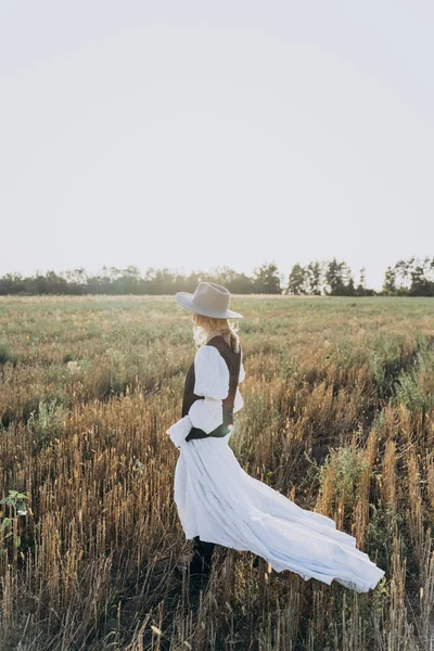 站在外地的时尚女人在长白色礼服的侧视图 — 图库照片