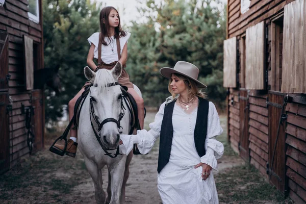 Stijlvolle Vrouw Vasthouden Hoofdstel Met Dochter Paardrijden Paard — Stockfoto