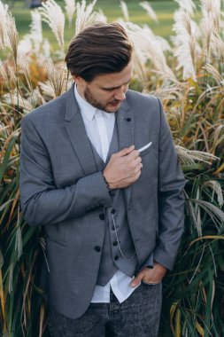 uruguaylı pampas çim arka plan karşı poz gri takım elbise yakışıklı adam