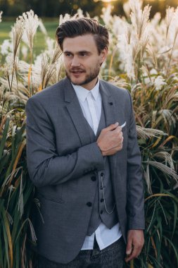 uruguaylı pampas çim arka plan karşı poz gri takım elbise yakışıklı adam
