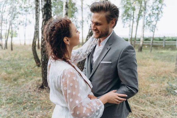 美丽的孕妇在白色礼服与英俊的男子面对面在伯奇格罗夫 — 图库照片