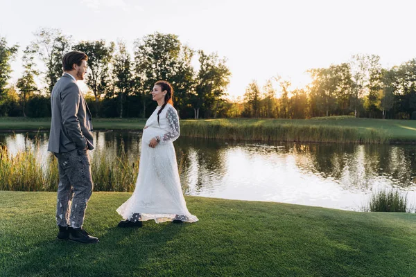 Bela Mulher Grávida Vestido Branco Com Homem Bonito Andando Gramado — Fotografia de Stock