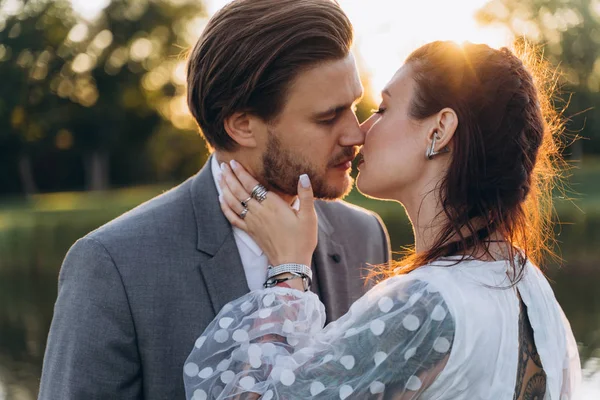 Krásná Těhotná Žena Bílých Šatech Pohledným Mužem Líbáním Zeleném Trávníku — Stock fotografie