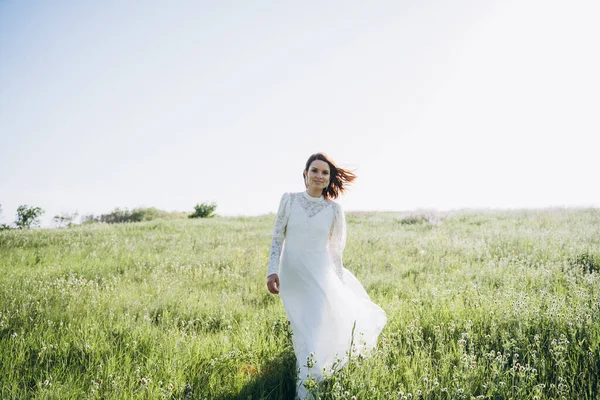 Tarlada poz veren uzun beyaz elbiseli güzel bir kadın. 