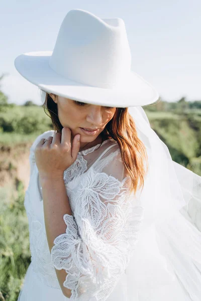 Çayırda Duran Fötr Şapkalı Beyaz Elbiseli Şık Gelin Portresi — Stok fotoğraf