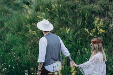 Beyaz elbiseli güzel bir kadın ve parkta yürüyen yakışıklı bir adam.