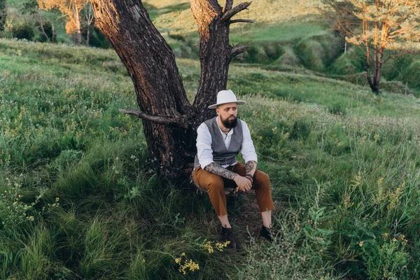 Ağaçta Oturan Şapkalı Yakışıklı Adam — Stok fotoğraf