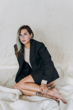 Stüdyoda kameraya poz veren ciddi bir kadın.