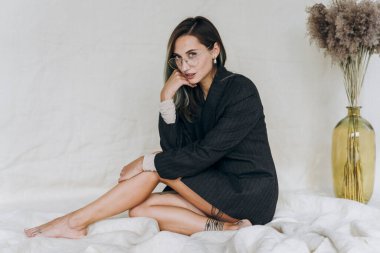 Stüdyoda kameraya poz veren ciddi bir kadın.