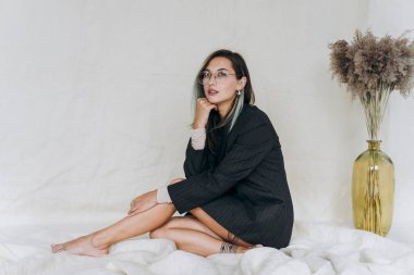 Stüdyoda kameraya poz veren ciddi bir kadın.