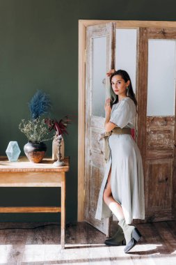 Modern iç mekanda poz veren dövmeli çekici bir kadın.