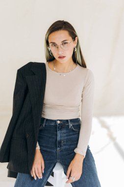  Ceketli şık bir kızın portresi sandalyede oturuyor. 