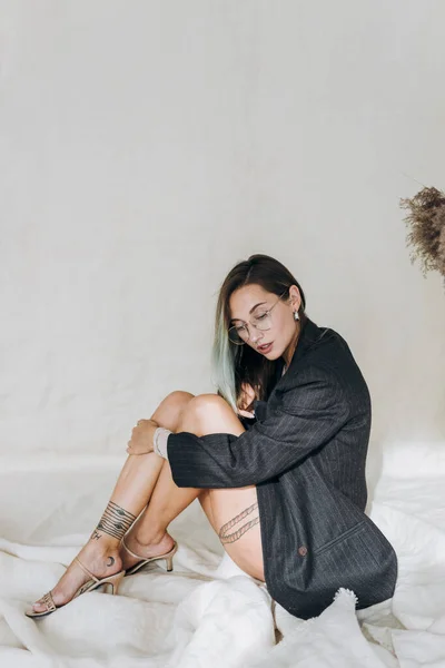 Stüdyoda Kumaş Üzerinde Oturan Şık Dövmeli Kız — Stok fotoğraf