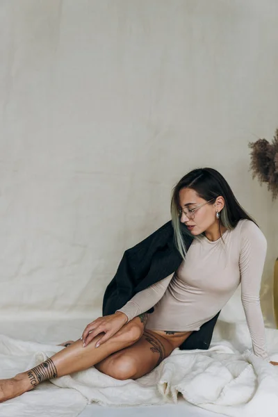 Ceketli Dövmeli Kadın Kumaşın Üzerinde Oturuyor — Stok fotoğraf