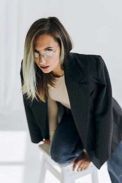 Modelo Feminino Posando Jaqueta Enquanto Sentado Cadeira — Fotografia de Stock