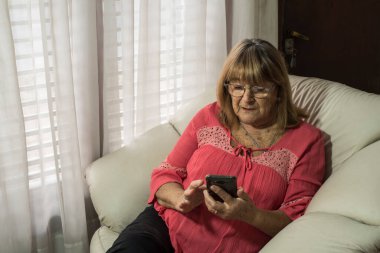 Daha yaşlı bir kadın sosyal uzaklıkla buluşurken iletişim kurmak için modern teknolojileri kullanıyor.